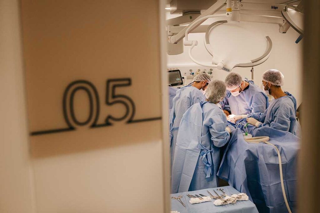 Chirurgisches Team im Operationssaal während einer Hüft-Operation, im Vordergrund chirurgische Instrumente – Symbolbild zu Nervenschädigung nach einer Hüft-OP